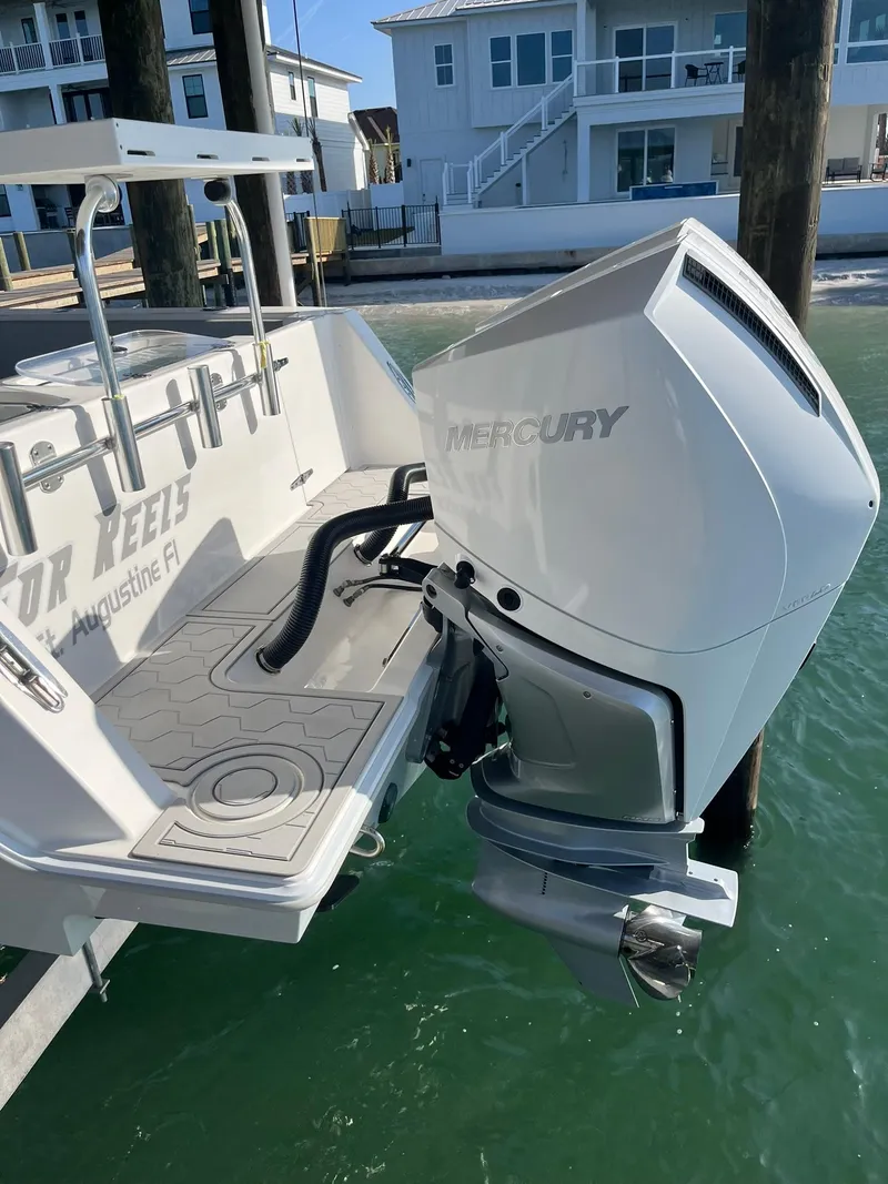 Slide: The Image of 2021 Contender 32ST boat with Mercury outboard engine, docked near waterfront homes. - 4