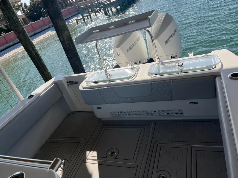 Slide: The Image of 2021 Contender 32ST boat deck with dual Mercury engines, docked by clear blue water. - 5