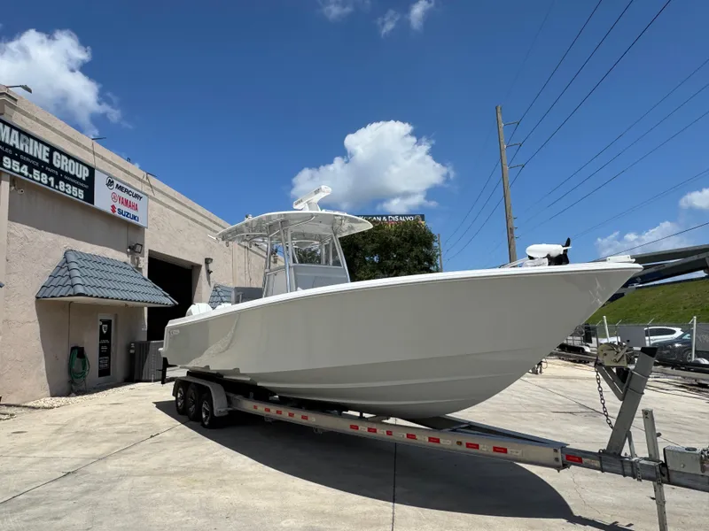 Slide: The Image of 2021 Contender 32ST boat on trailer outside marine shop under blue sky. - 7