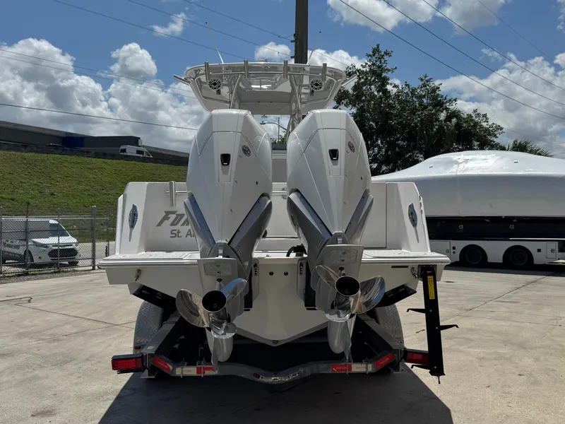 Slide: The Image of 2021 Contender 32ST boat with dual outboard engines on a trailer, parked outdoors. - 9