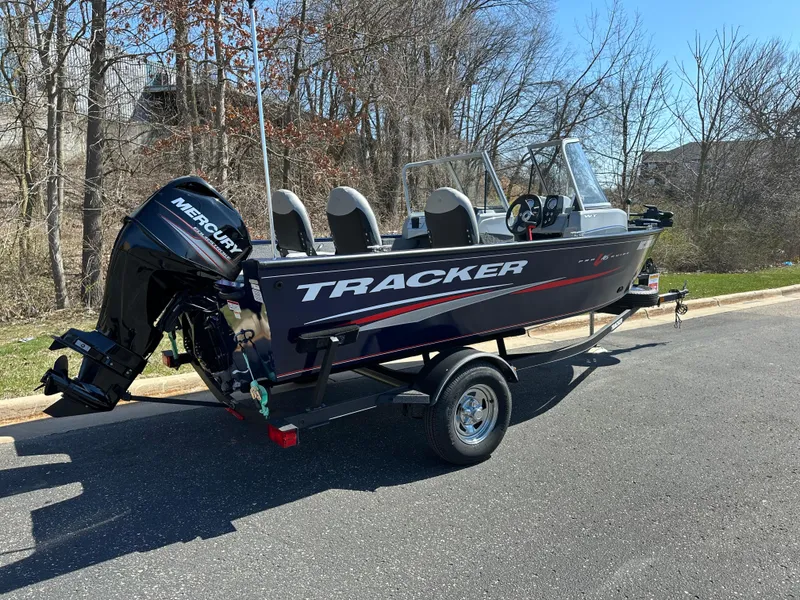 Slide: The Image of 2019 Tracker Pro Guide V-16 WT boat on trailer, parked outdoors. - 2