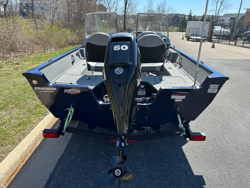 Slide: The Image of 2019 Tracker Pro Guide V-16 WT boat with 60 HP motor, parked outdoors. - 3