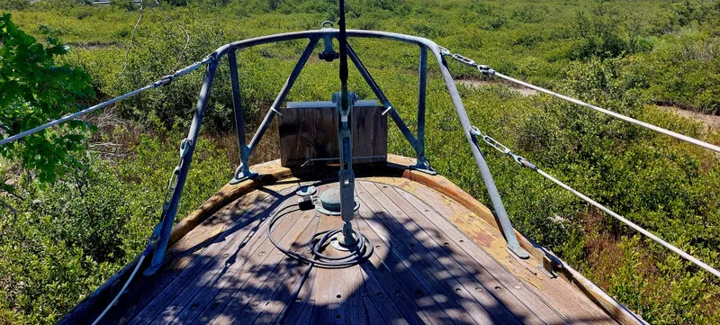 Slide: The Image of 1955 Concordia 41 Yawl with wooden deck, surrounded by lush greenery. - 14