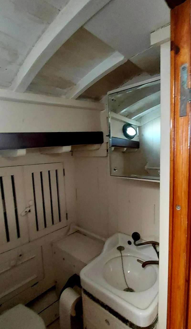 Slide: The Image of Vintage 1955 Concordia 41 Yawl bathroom with sink, mirror, and wooden accents. - 5