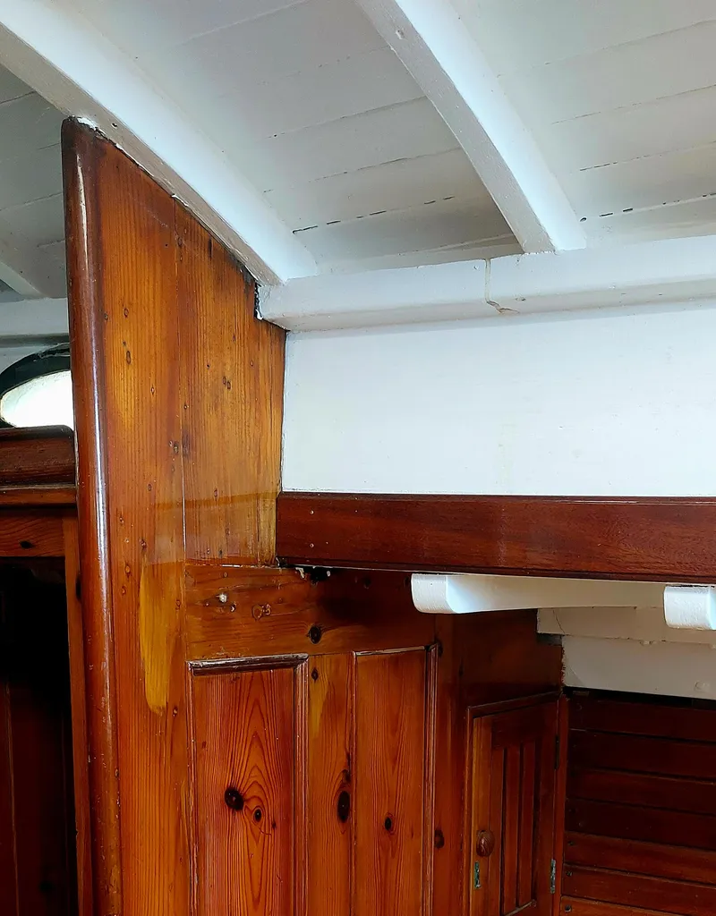 Slide: The Image of Interior of 1955 Concordia 41 Yawl, showcasing wooden paneling and classic nautical design. - 6