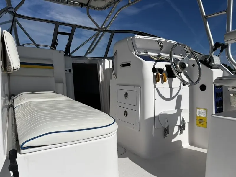 Slide: The Image of 2001 Pro-Line 27 Express boat interior with steering wheel and seating under a clear blue sky. - 14