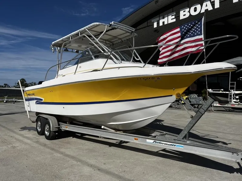 Slide: The Image of 2001 Pro-Line 27 Express boat on trailer, yellow and white, with American flag. - 2