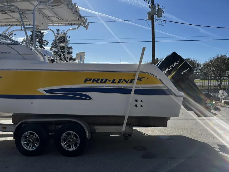 Slide: The Image of 2001 Pro-Line 27 Express boat on trailer, featuring yellow and blue accents, with Mercury engine. - 6