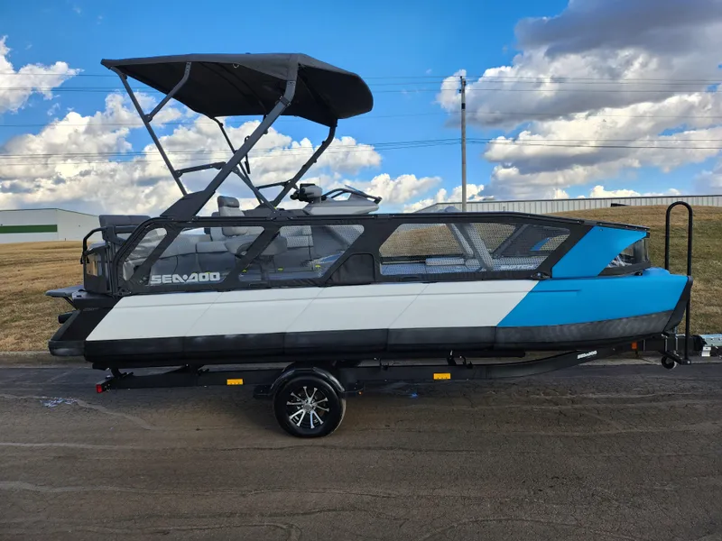 Slide: The Image of 2022 Sea-Doo Switch Sport 21 pontoon boat on trailer, under blue sky. - 4