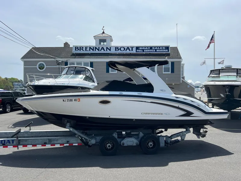 The Image of 2011 Chaparral 264 Sunesta boat on trailer at marina, clear sky background. - 0