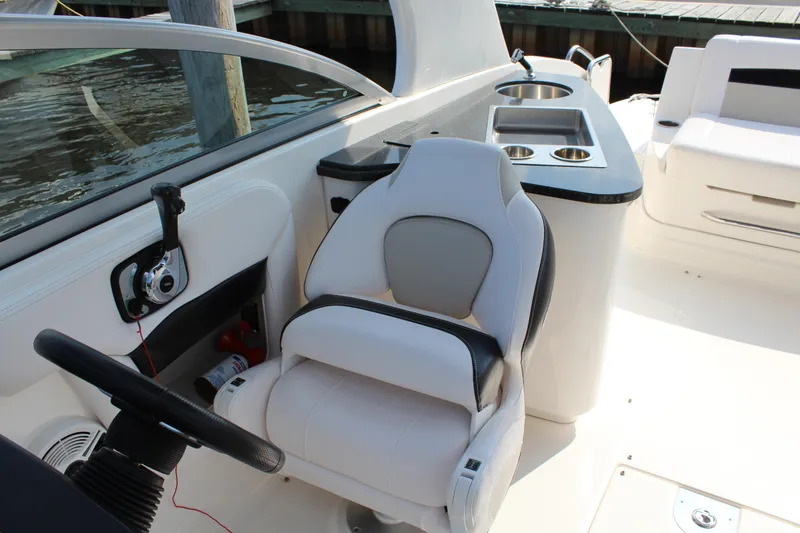 Slide: The Image of 2011 Chaparral 264 Sunesta boat interior with helm and seating area. - 24