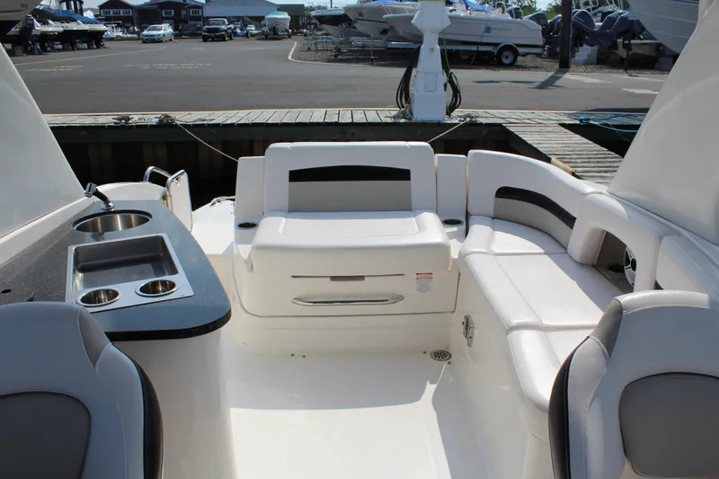 Slide: The Image of 2011 Chaparral 264 Sunesta boat interior with seating and kitchenette at a marina. - 26