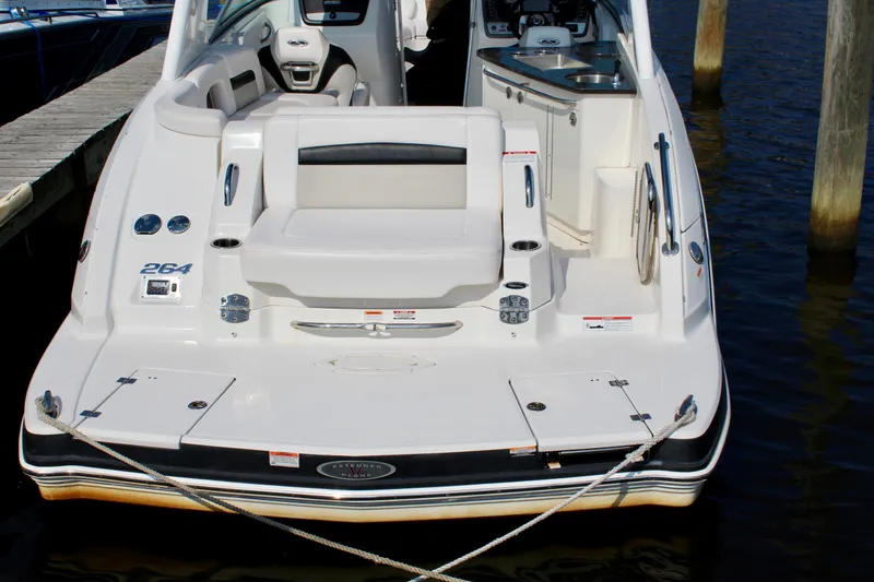 Slide: The Image of 2011 Chaparral 264 Sunesta boat docked, showcasing spacious rear seating and swim platform. - 31