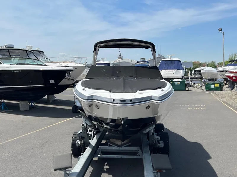 Slide: The Image of 2011 Chaparral 264 Sunesta boat on trailer in marina under clear sky. - 4