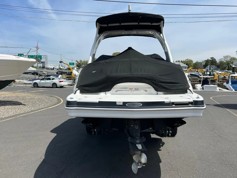 Slide: The Image of 2011 Chaparral 264 Sunesta boat, rear view, covered, parked outdoors. - 7