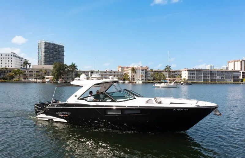 Slide: The Image of 2020 Monterey 385 Super Express boat cruising on a sunny day in a city harbor. - 10