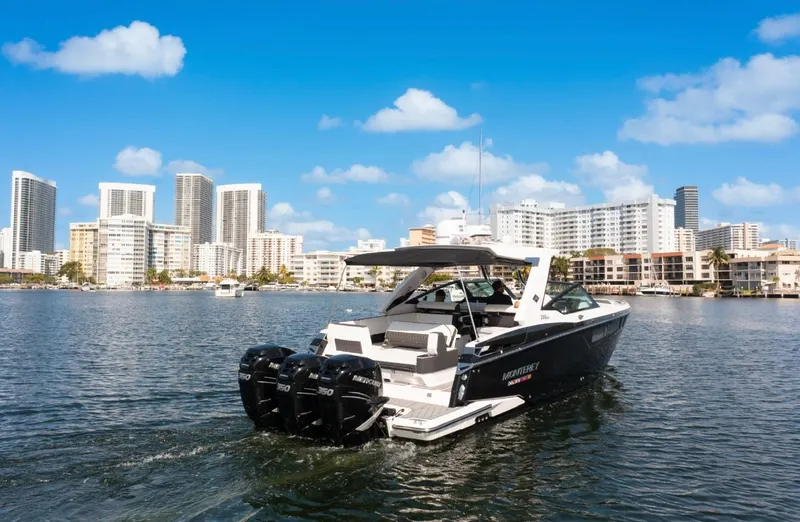 Slide: The Image of 2020 Monterey 385 Super Express boat cruising near city skyline under blue sky. - 13