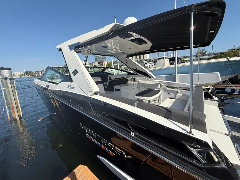 Slide: The Image of 2020 Monterey 385 Super Express boat docked at marina, showcasing sleek design and spacious deck. - 17