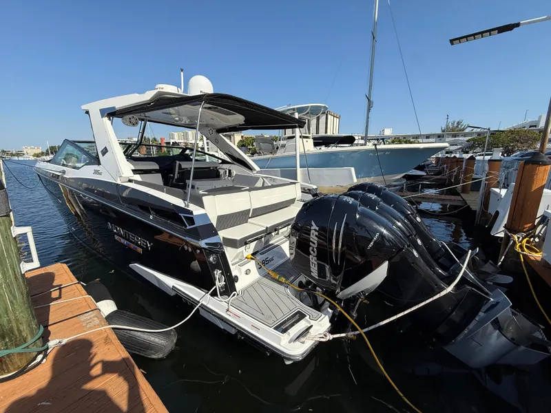 Slide: The Image of 2020 Monterey 385 Super Express boat docked with powerful outboard engines, sunny marina setting. - 19