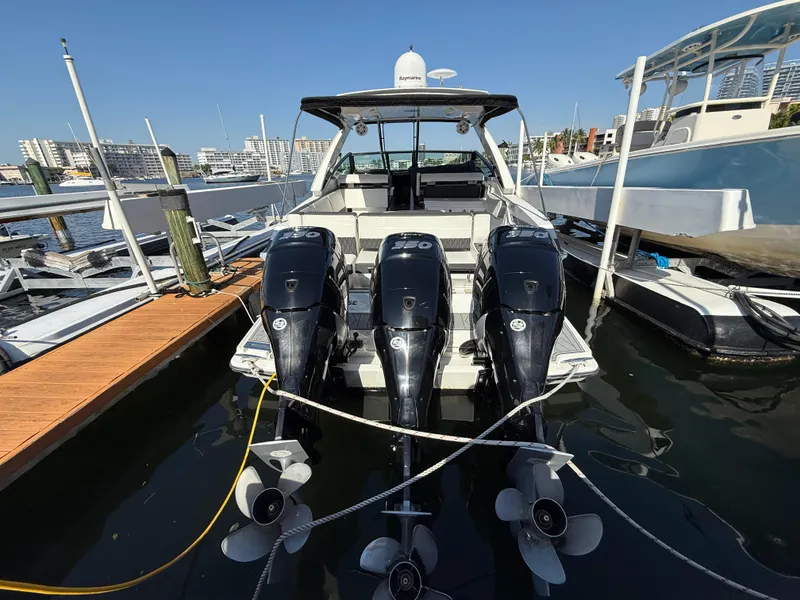 Slide: The Image of 2020 Monterey 385 Super Express boat docked with triple outboard engines. - 20