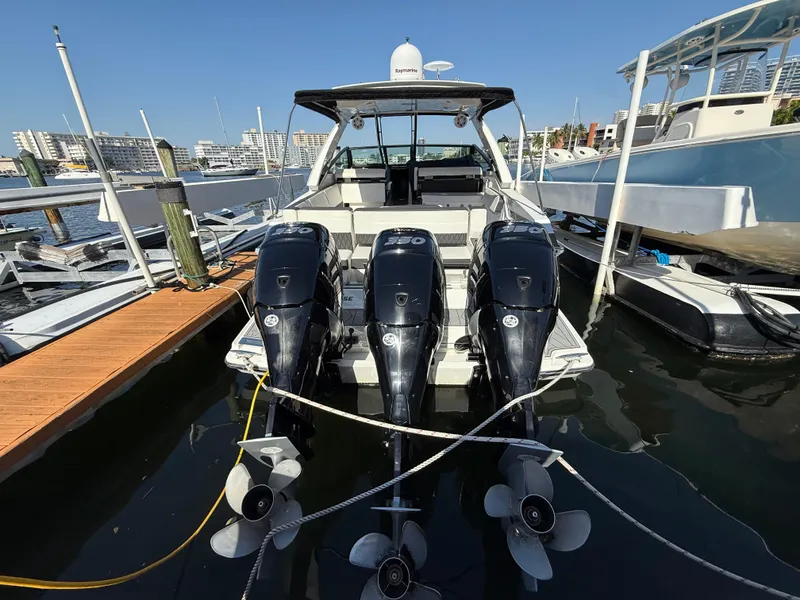 Slide: The Image of 2020 Monterey 385 Super Express boat docked with triple outboard engines. - 21