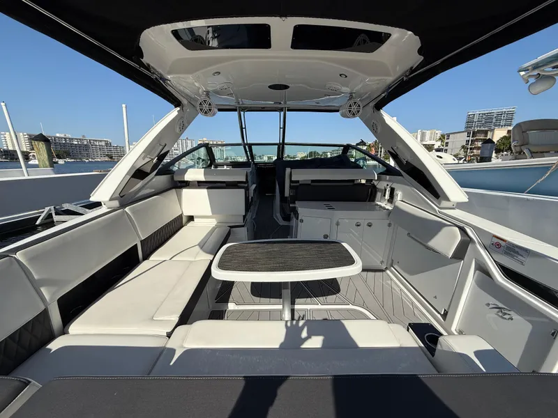 Slide: The Image of 2020 Monterey 385 Super Express luxury yacht interior with seating and table, docked in marina. - 26