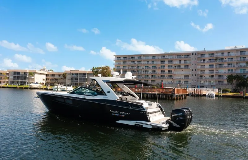 Slide: The Image of 2020 Monterey 385 Super Express yacht cruising near waterfront buildings under a clear blue sky. - 3