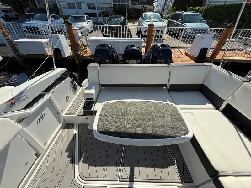 Slide: The Image of 2020 Monterey 385 Super Express boat interior with seating and table at a marina. - 31