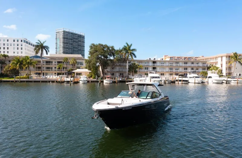 Slide: The Image of 2020 Monterey 385 Super Express cruising in a marina with palm trees and buildings in the background. - 5