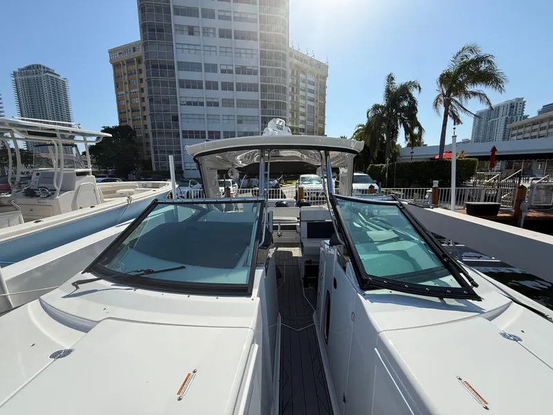 Slide: The Image of 2020 Monterey 385 Super Express boat docked near modern buildings and palm trees. - 52