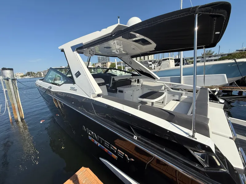 Slide: The Image of 2020 Monterey 385 Super Express boat docked, featuring sleek design and spacious deck. - 61