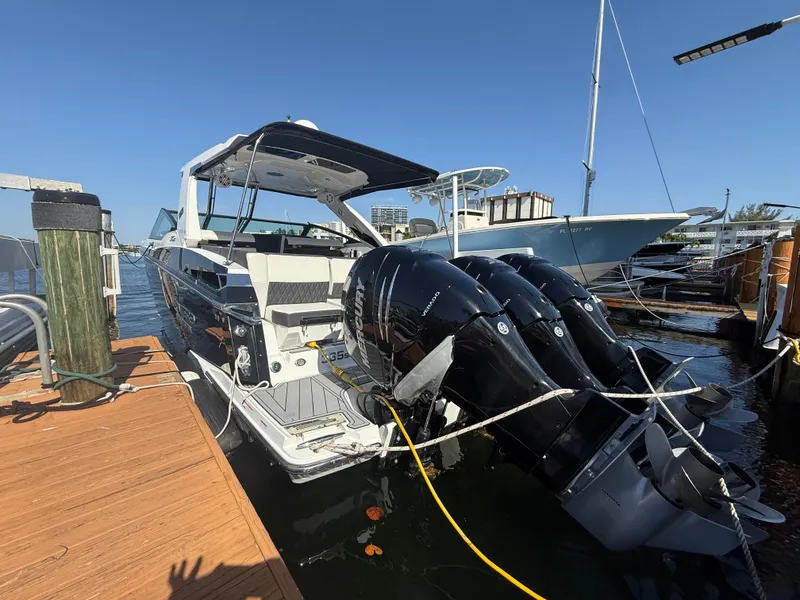 Slide: The Image of 2020 Monterey 385 Super Express boat docked with triple outboard engines. - 63