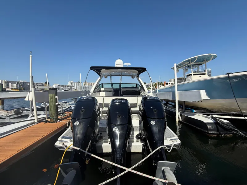 Slide: The Image of 2020 Monterey 385 Super Express boat docked with triple outboard engines. - 64