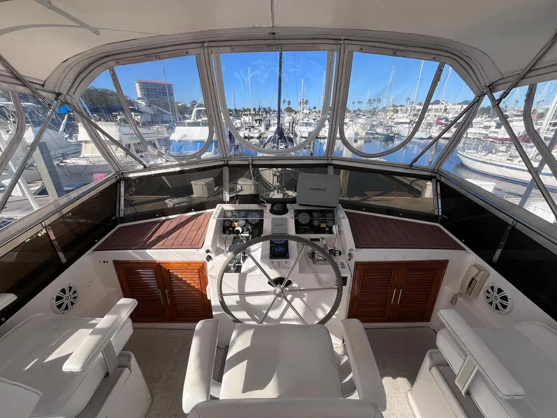 Slide: The Image of 1989 CHB Oceania 42 yacht helm with panoramic marina view, featuring modern navigation equipment. - 12