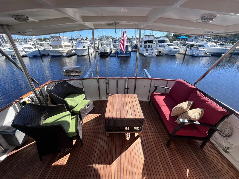 Slide: The Image of 1989 CHB Oceania 42 yacht deck with seating, table, and marina view. - 16