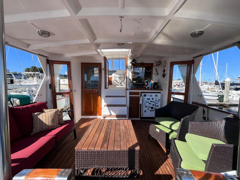 Slide: The Image of Interior of 1989 CHB Oceania 42 yacht with seating and wooden table in a marina setting. - 18
