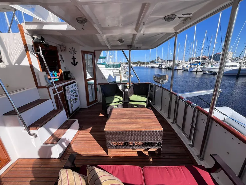 Slide: The Image of 1989 CHB Oceania 42 yacht deck with seating, wooden flooring, and marina view. - 20