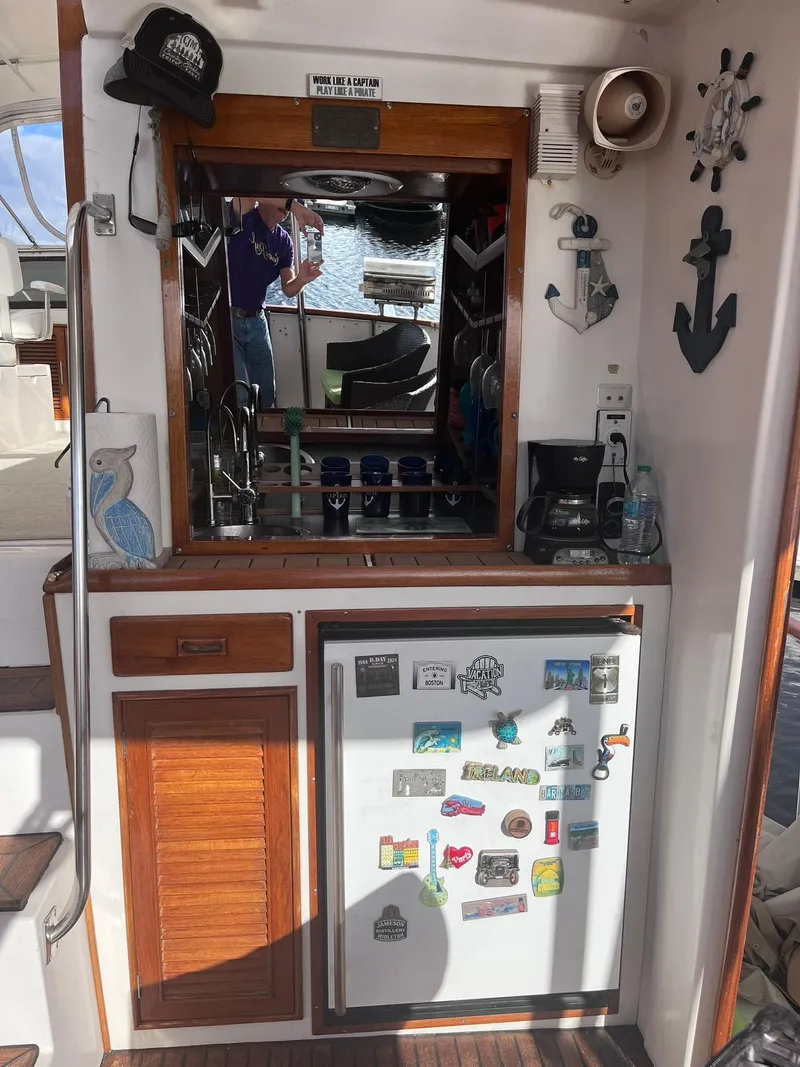 Slide: The Image of 1989 CHB Oceania 42 boat interior with fridge, nautical decor, and wooden cabinetry. - 22