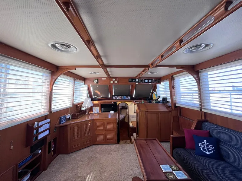Slide: The Image of Interior of 1989 CHB Oceania 42 yacht with wood paneling and striped seating. - 35