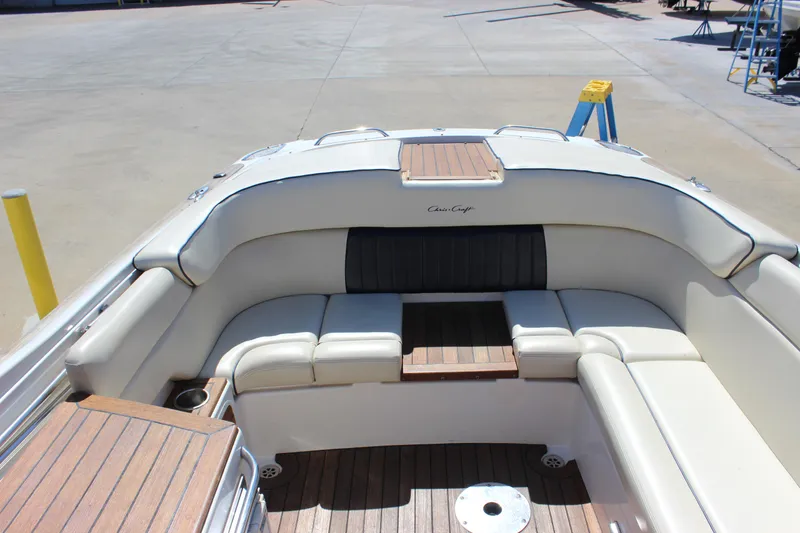 Slide: The Image of 2004 Chris-Craft Corsair 25 boat interior with white seating and wooden accents. - 12