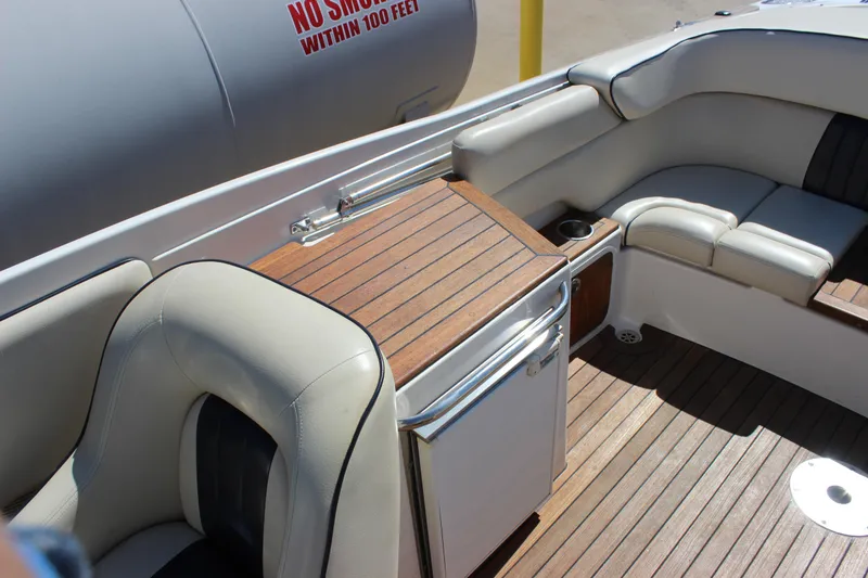 Slide: The Image of 2004 Chris-Craft Corsair 25 interior with wooden deck and cushioned seating. - 16