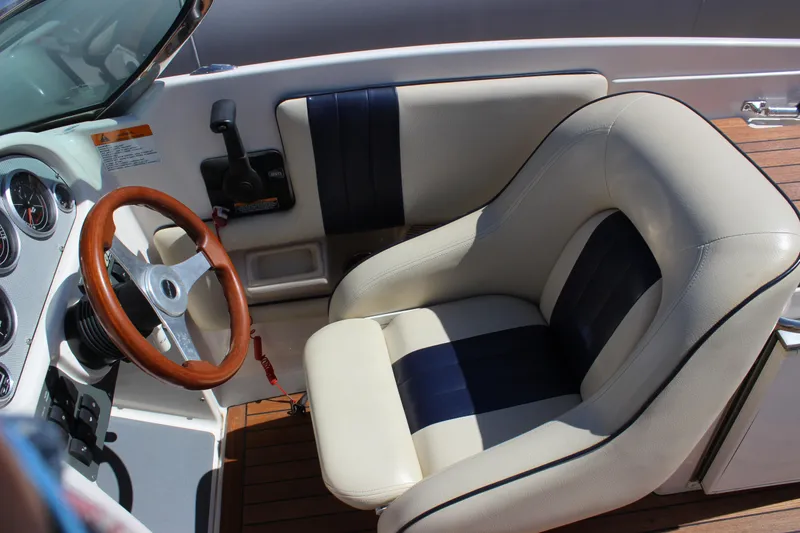 Slide: The Image of 2004 Chris-Craft Corsair 25 cockpit with leather seat and wooden steering wheel. - 18