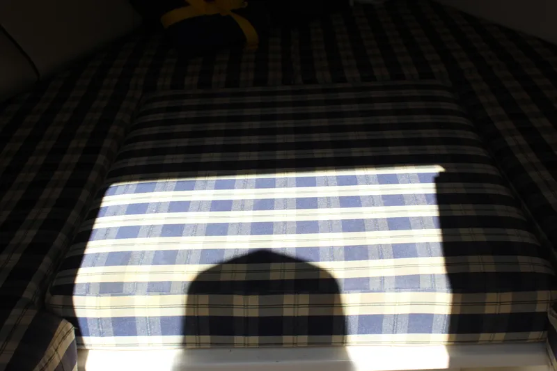 Slide: The Image of Plaid upholstery inside 2004 Chris-Craft Corsair 25 boat cabin, partially shadowed. - 29