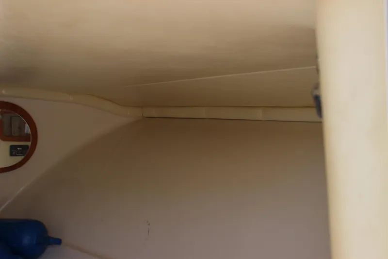 Slide: The Image of 2004 Chris-Craft Corsair 25 interior cabin with beige walls and a round mirror. - 30