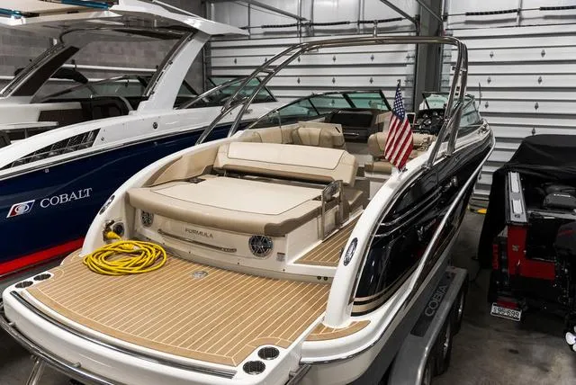 Slide: The Image of 2016 Formula 290 Bowrider boat in storage, featuring a sleek design and American flag. - 4