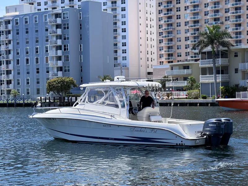 The Image of 2006 Hydra-Sports 33VX boat cruising near waterfront buildings. - 0