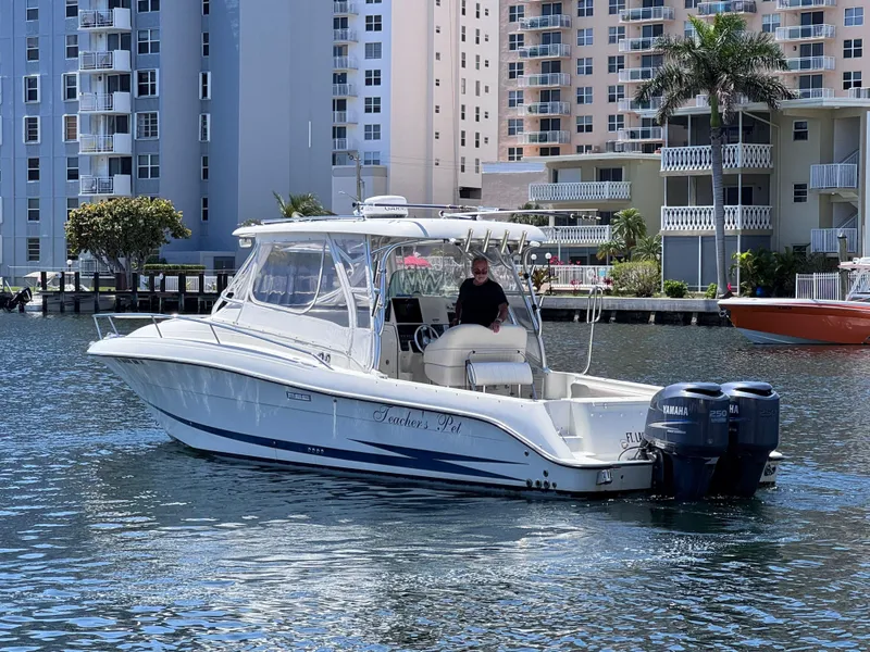 Slide: The Image of 2006 Hydra-Sports 33VX boat cruising in a marina with modern buildings in the background. - 2
