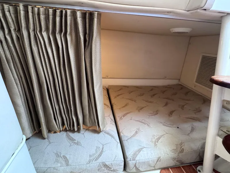 Slide: The Image of 2006 Hydra-Sports 33VX cabin interior with patterned bedding and privacy curtain. - 25