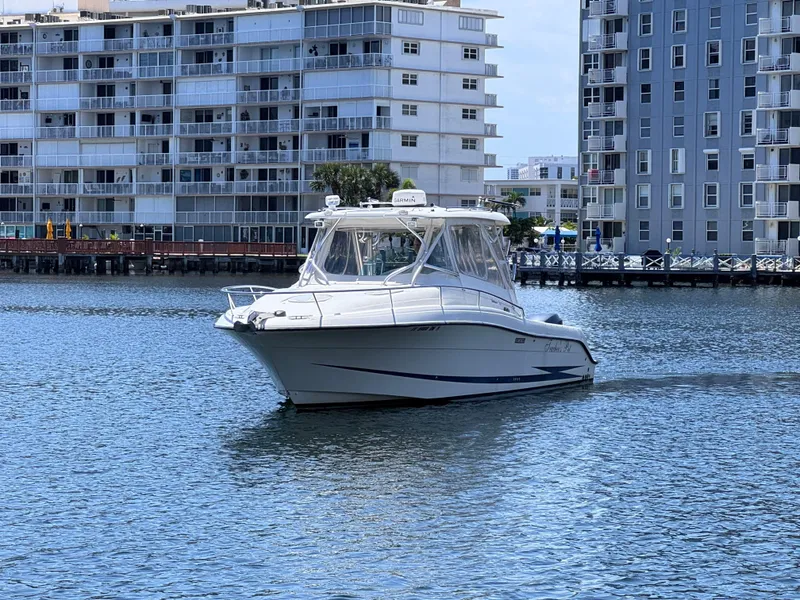 Slide: The Image of 2006 Hydra-Sports 33VX boat cruising near waterfront buildings. - 7