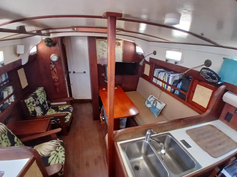 Slide: The Image of Interior of a 1977 Dickerson 41 sailboat with cozy seating and wooden finishes. - 11